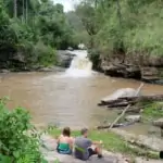 group of people resting at small waterfall