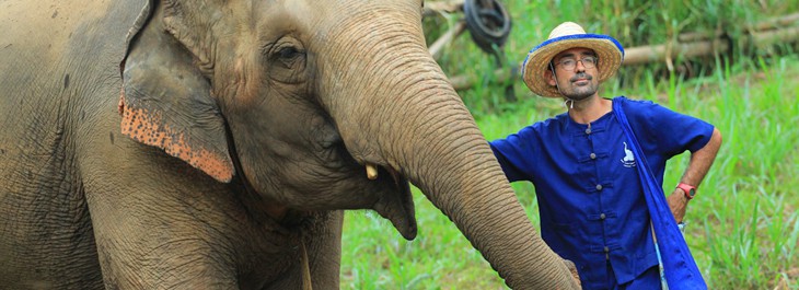 man posing with an elephant in jungle