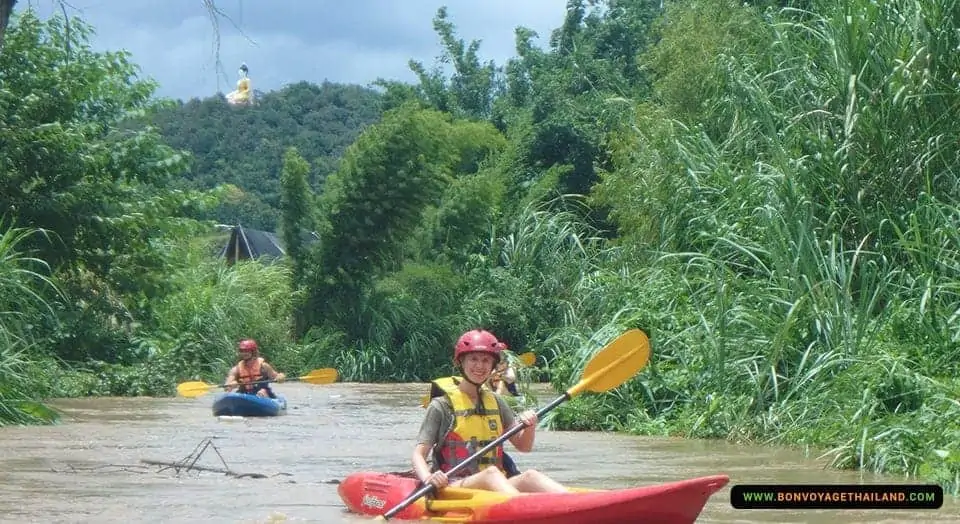 woman kayaking through chiang dao jungle river