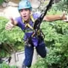 young man giving 2 thumbs up while descending from treetop