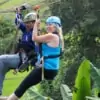 couple ziplining together over rice filed