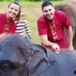 man and woman bathing elephant