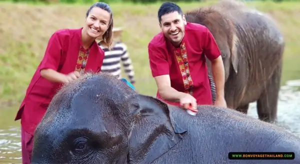 man and woman bathing elephant