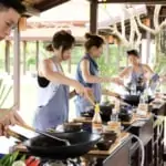 group of people cooking thai food at cooking station