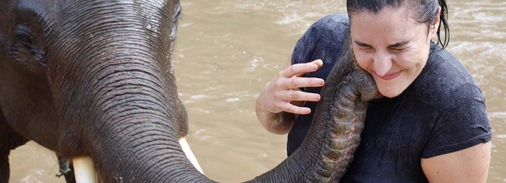 close up of elephant kissing a lady in river