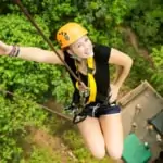 smiling woman descending from treetop