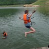 young boy jumping in lake