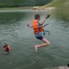 young boy jumping in lake