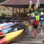 group of young people getting ready to kayak