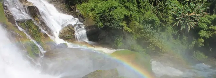 cascading waterfall with rainbow