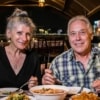man and woman enjoying traditional thai dinner on river cruise