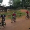 group of people mountain biking through hill tribe village