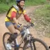 young woman mountain biking on a dirt road