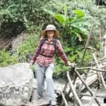 women trekking over small bamboo bridge on pha dok siew nature trail