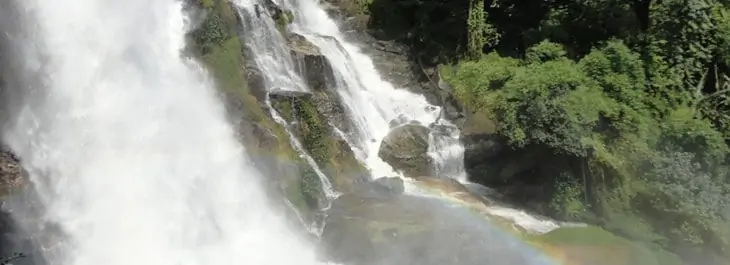 cascading waterfall with rainbow