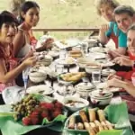 men and women having home-cooked thai meal