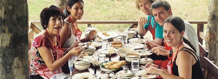 men and women having home-cooked thai meal