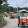 a convoy of tuk-tuks in Thai countryside