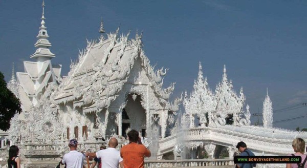 tourists taking photos of white temple or wat rong khun