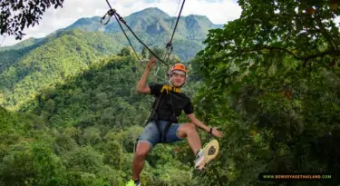 man ziplining through jungle
