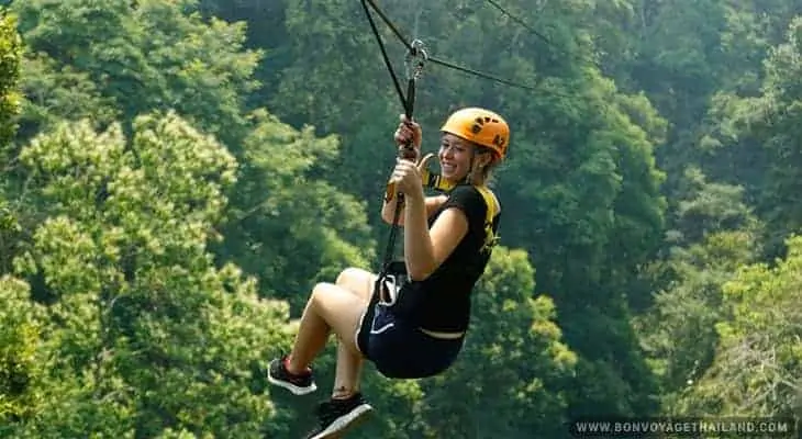 young woman ziplining through jungle