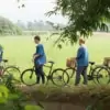 men and women walking their bicycles along rice paddy