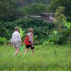 women walking through rice paddy at lisu lodge