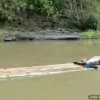 young man and woman bamboo rafting along local river