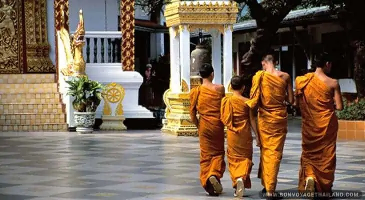 a group of buddhist monks walking in temple