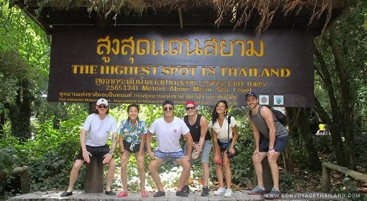 group of people posing for a photo at highest point in thailand