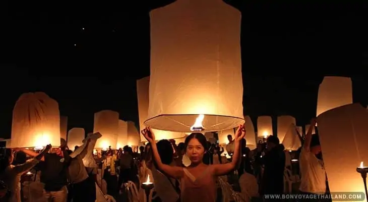 woman preparing to release lit paper lantern into the sky during yeepeng festival