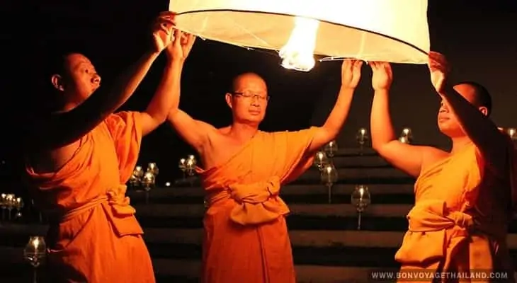 monks releasing lit lantern during yeepeng festival