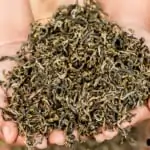 close up of handful of black tea at araksa tea garden