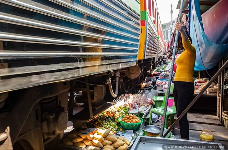 Marché ferroviaire de Mae Klong Femmes attendant le passage du train