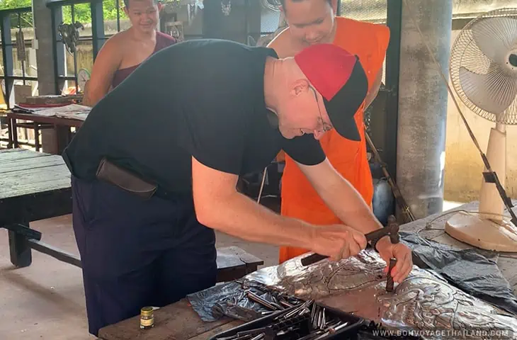 Tourist working on a silver panel at the Silver Temple in Chiang Mai